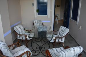 a group of chairs and a glass table in a room at EOΣ in Nikiana