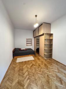 ein Schlafzimmer mit einem Bett und einem Holzboden in der Unterkunft Niecała Twelve - Old Town Hideaway in Lublin