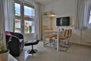 a living room with a table and chairs and a tv at Villa A in Pirovac