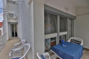 a balcony with a table and chairs on a building at Villa A in Pirovac