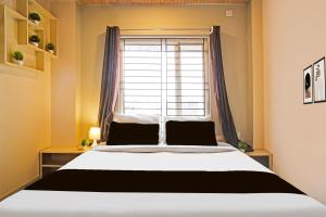 a bedroom with a bed in front of a window at Hotel O Air Stop in Guwahati