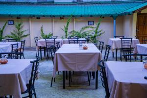a group of tables and chairs with white table cloth at Balrampur House Heritage Hotel in Nainital +17 photos