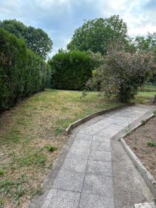 a walkway in a park with bushes and trees at Le Champ du Bonheur in Esprels