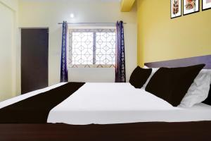 a bedroom with a white bed and a window at Hotel O Shalom home stay in Goa