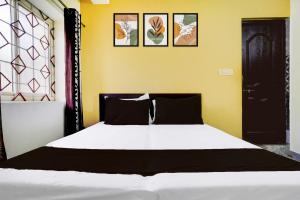 a bedroom with a white bed with four pictures on the wall at Hotel O Shalom home stay in Goa +22 photos