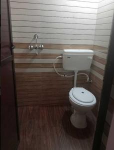 a bathroom with a white toilet in a room at Hotel Passion Resort in Kolkata