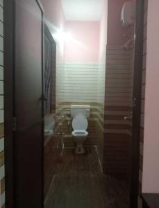 a bathroom with a white toilet in a room at Hotel Passion Resort in Kolkata