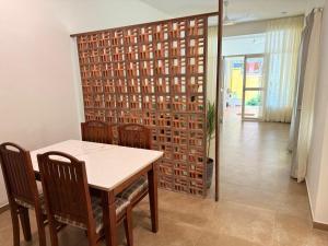 a dining room with a table and chairs and a wall at Hibiscus By Tara Suites in Jāmb