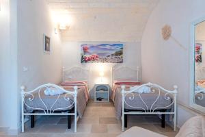 a room with two beds and a couch at Lamia il Melograno in Ostuni