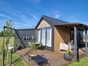 a tiny house with a deck with a table and chairs at Rita Sapnis in Nida