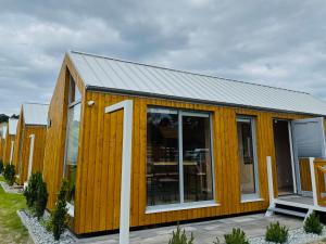 a wooden house with the number seven on it at Zagroda Sosnowa in Dębki