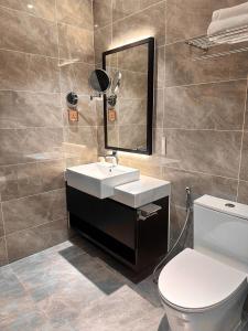 Hạ Long Sapphire Premium في ها لونغ: حمام مزود بمرحاض ومغسلة ومرآة +8 صور