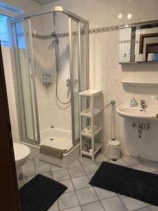 a bathroom with a shower and a toilet and a sink at Ferienwohnungen Gebhard in Scheidegg +3 photos