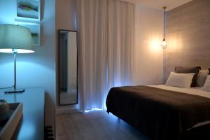 a bedroom with a bed and a mirror and a lamp at Hotel Mar Bravo in Nazaré