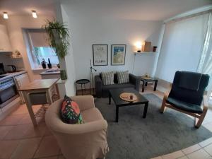 a living room with a couch and chairs and a table at Ferienwohnung an den Leinewiesen in Schwarmstedt