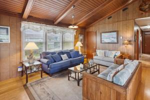 una sala de estar con muebles azules y paredes de madera. en 5005 - Bristow`s Bungalow, en Kill Devil Hills