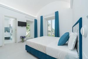 a bedroom with a large bed with blue accents at Villa Zagara in Amalfi