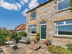 una casa in mattoni con porta verde e patio di 4 bed in North York Moors 82262 a Danby