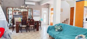 a living room with a blue couch and a dining room at Maisonette Mangana in Xanthi