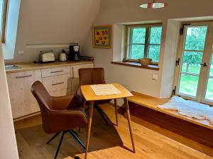 a kitchen with a table and chairs in a room at Hof Allerniederung in Häuslingen