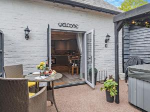 a patio with a table and a door with a welcome sign at 1 Bed in Christchurch 54901 in Ringwood