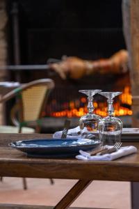 a table with a plate and wine glasses on it at Domaine Pozzo di Mastri hôtel & spa in Figari