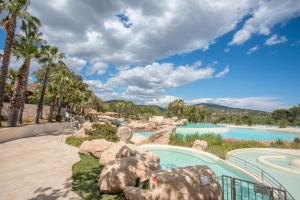 einen Pool in einem Resort mit Bäumen und Wasser in der Unterkunft Grimaud 4 personnes clim vue mer in Grimaud