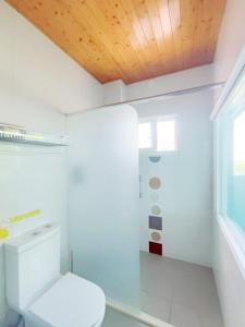ein Badezimmer mit einem weißen WC und einer Holzdecke in der Unterkunft Ding Shian B&B in Hualien
