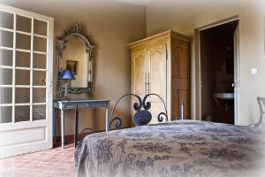 ein Schlafzimmer mit einem Bett und einem Spiegel in der Unterkunft gîte Mas Antinea in Mazan