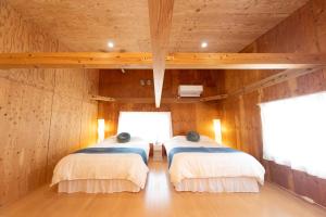 汤浅町すはらシーサイドハウス和歌山的一间木墙房间里有两张床