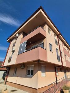 Un edificio alto con ventanas a los lados. en Apartman Dvojka Banjaluka, en Banja Luka
