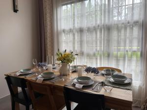 ein Holztisch mit Stühlen und einer Vase mit Blumen in der Unterkunft Garden Villa by Wedelia Homes in Tengeru + 15 Fotos