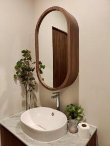 ein Badezimmer mit einem weißen Waschbecken und einem Spiegel in der Unterkunft Chobjai Hostelry - Chaw Cher Home at Bang Kra Jao in Bang Krasop + 9 Fotos