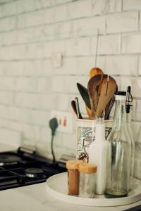 eine Küchentheke mit einem Behälter mit Utensilien und einem Herd in der Unterkunft Garden Villa by Wedelia Homes in Tengeru