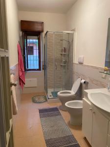 a bathroom with a shower and a toilet and a sink at Sunset Villa Favazzina- Piscina e vista sul Mare in Favazzina +28 photos
