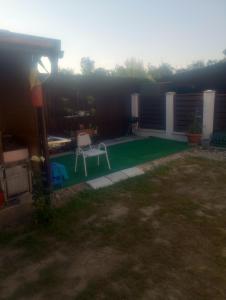 RemeteaにあるCasă țărănească Marikaのテーブルと椅子のある緑の芝生のある裏庭