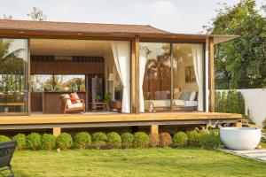 ein Haus mit einer Terrasse und einem Wohnzimmer in der Unterkunft Chobjai Hostelry - Chaw Cher Home at Bang Kra Jao in Bang Krasop