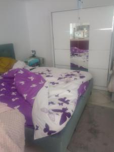 RemeteaにあるCasă țărănească Marikaの紫と蝶の模様のシーツが敷かれたベッドのある寝室 +7枚の写真