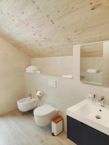 un bagno con un WC bianco e un lavandino di Symphony Camere e Ristoro a Sobrio