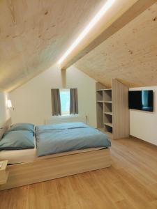 una camera da letto con un grande letto e una televisione di Symphony Camere e Ristoro a Sobrio