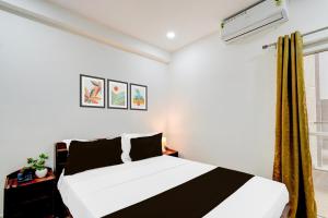 a bedroom with a black and white bed and a window at Super Townhouse Nallagandla Nest in Hyderabad