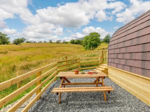 una mesa de picnic de madera sobre una valla en 1 Bed in Coniston 88961, en Coniston