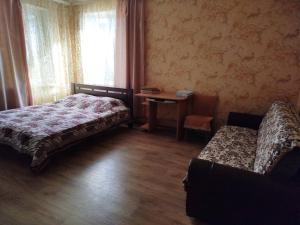 a bedroom with a bed and a chair and a table at Гостевой домик in Chornomorsk