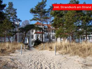 - un bâtiment sur la plage avec des arbres devant dans l'établissement Villa Strandidyll Apartment 15, Meerblick, inkl Strandkorb, à Binz
