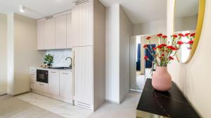 een keuken met een vaas met bloemen op een aanrecht bij CONTINENTAL Apartamenty Piamola in Krynica Morska