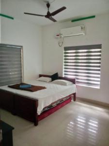 a bedroom with a bed and a ceiling fan at Farah Homestay in Varkala
