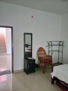 a bedroom with a bed and a mirror and a chair at Farah Homestay in Varkala