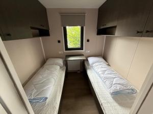 a small room with two beds and a window at Nieuw in 2025! Modern vakantiehuis aan de Waddenzee in Westerland
