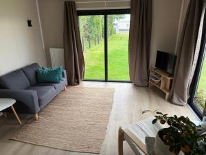 a living room with a blue couch and a tv at Nieuw in 2025! Modern vakantiehuis aan de Waddenzee in Westerland