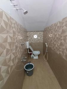 a bathroom with a toilet and a bucket at Christmas Rajan Home Stay in Tirunelveli